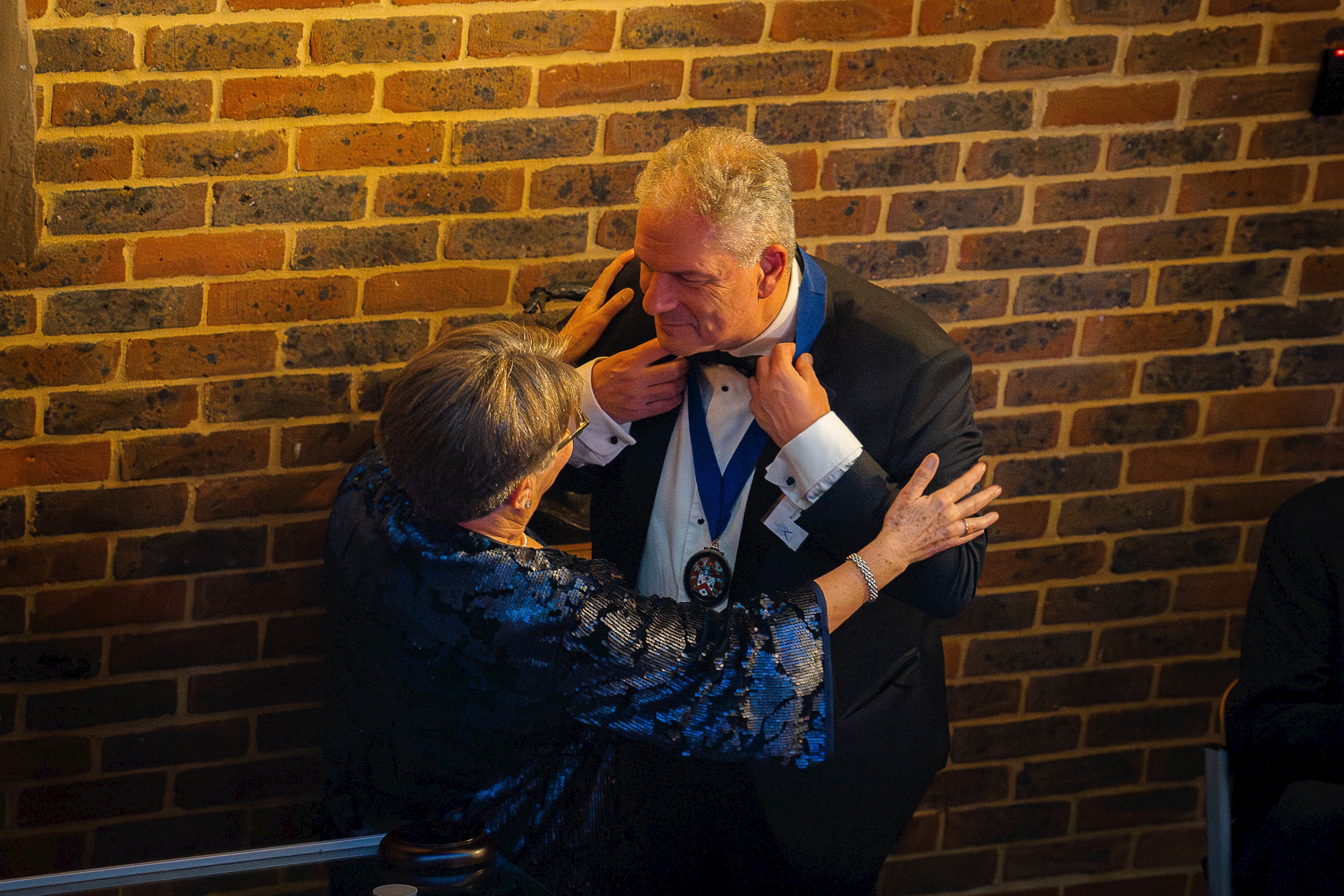 EAC President Reno Antoniades (Tulley's 1984) receives his medallion from former President Sue Lane